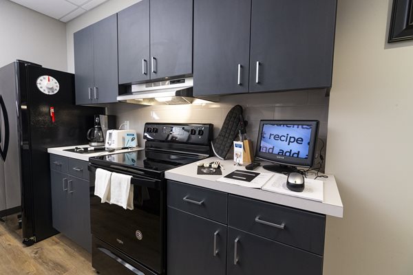 View of the kitchenette in Envision Dallas's model apartment with many different low vision assistive technology devices on display