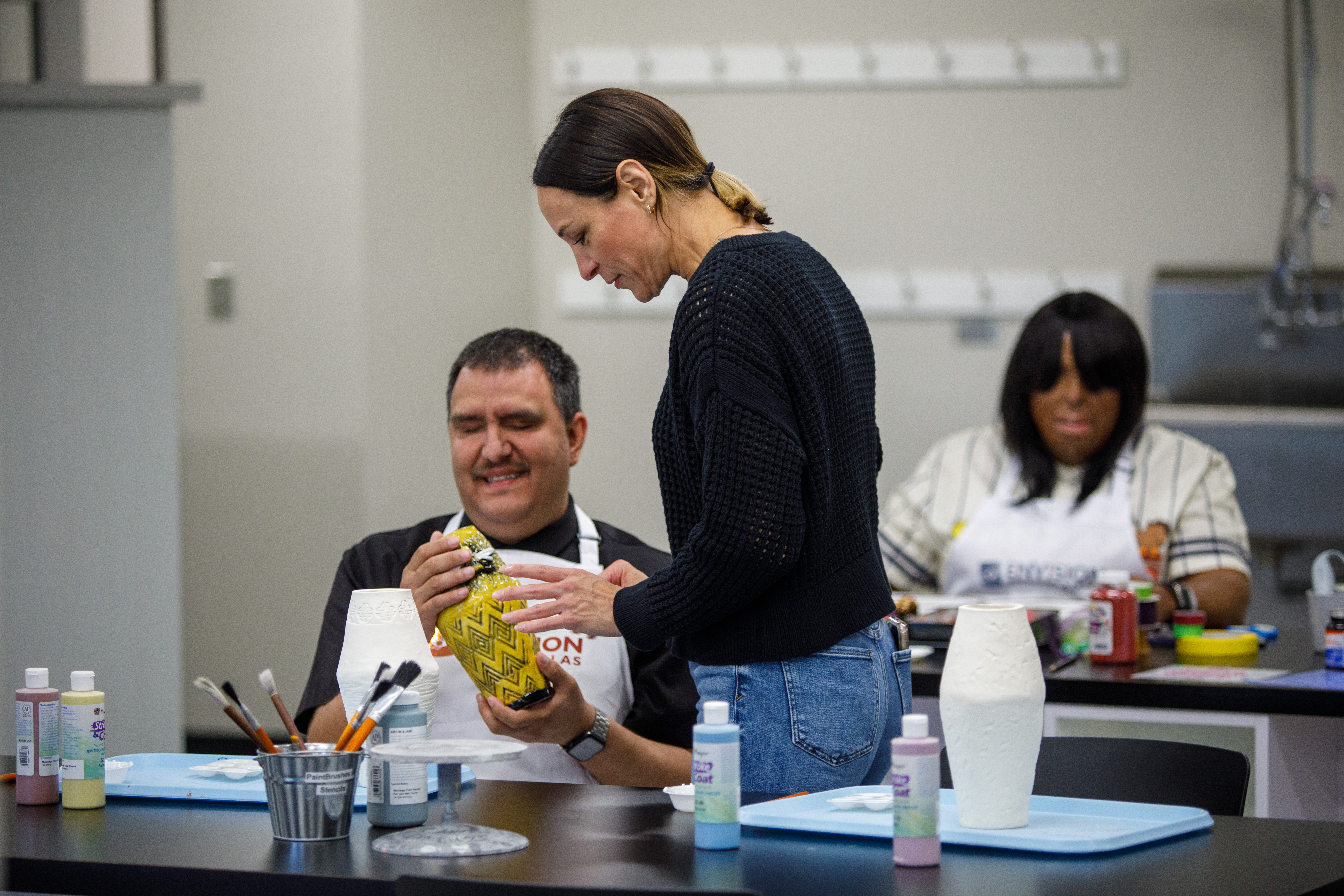 A client of services being shown how to use a magnifying glass with a flashlight.