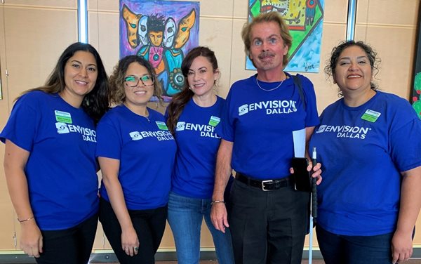 Five Envision Dallas employees pose for a picture in their royal blue matching t-shirts