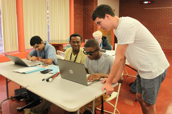 Andrew helps Level Up participants in assistive technology camp session.