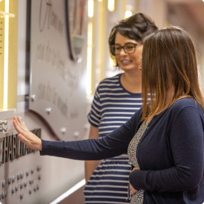 New employee at Envision Industries feels the braille on the history wall.