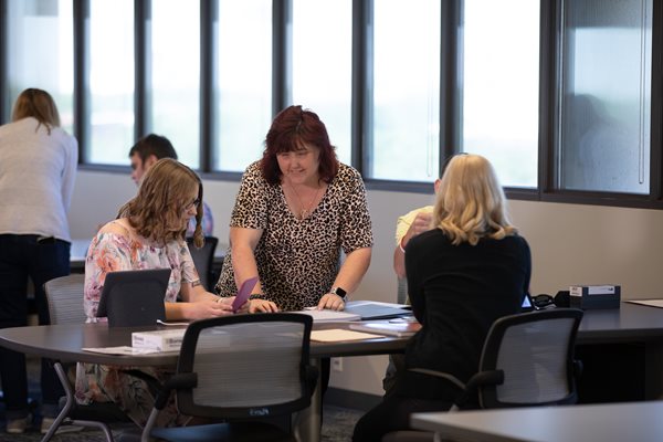 A women who is visually impaired collaborating with another woman who in a black shirt. 