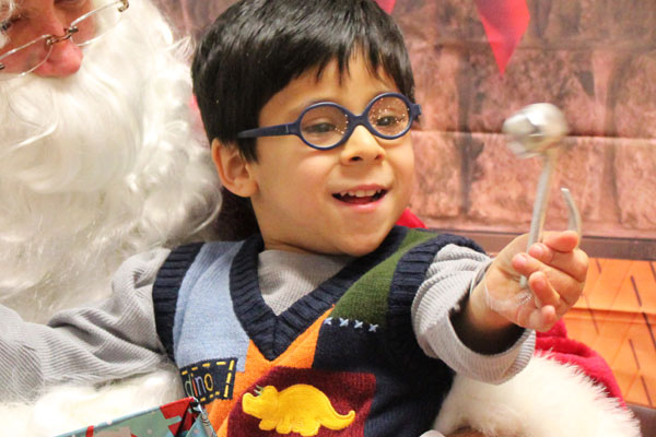 Aaron enjoys ringing a bell during Santa's visit at ECDC for the holidays.