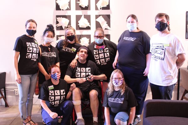 Team posing at art event.