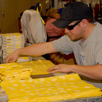 Man, who is blind, works on yellow material needed for a new product at Envision Industries.