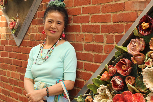 Tomiyo Tajiri standing in front of her Gallery Alley installment 