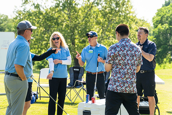 Envision staff enjoy a laugh with golfers at the Shotgun Cannon hole.