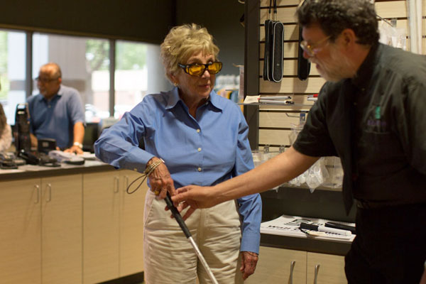 Woman gets instruction on how to use a white cane at the Envision Everyday Store.
