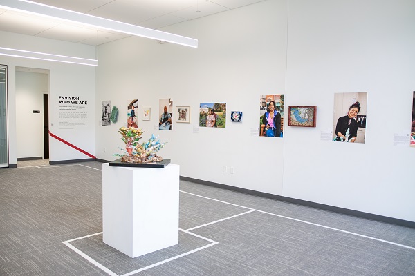 Empty space in Envision Arts Gallery with artwork displayed and white navigational tape on the floor