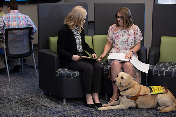 National Guide Dog Month: Etiquette, Facts and More Professional Envision employee stands outside the office with her guide dog.