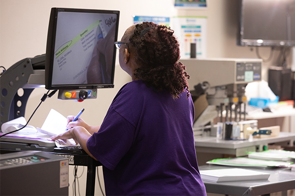 Mission in Motion: A Closer Look at What Sets Envision’s Services Apart Lori Griffin-Harge, Print Production Associate, marks up an order for a customer at Envision Print.