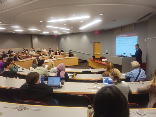 Group of low vision professionals sitting in a conference room watching  a presentation