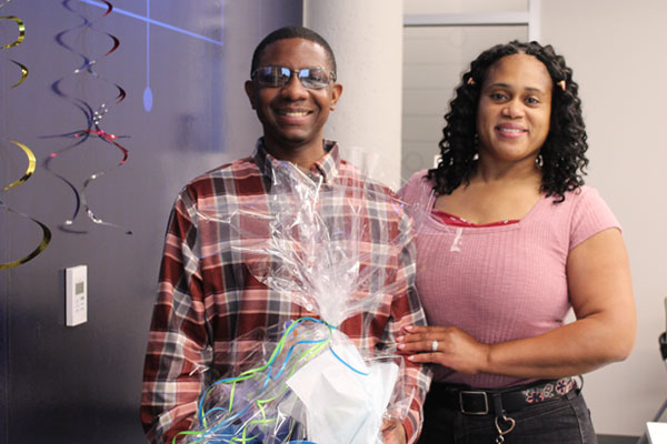 Sedrick smiling with wife Chiffonda at luncheon celebration.